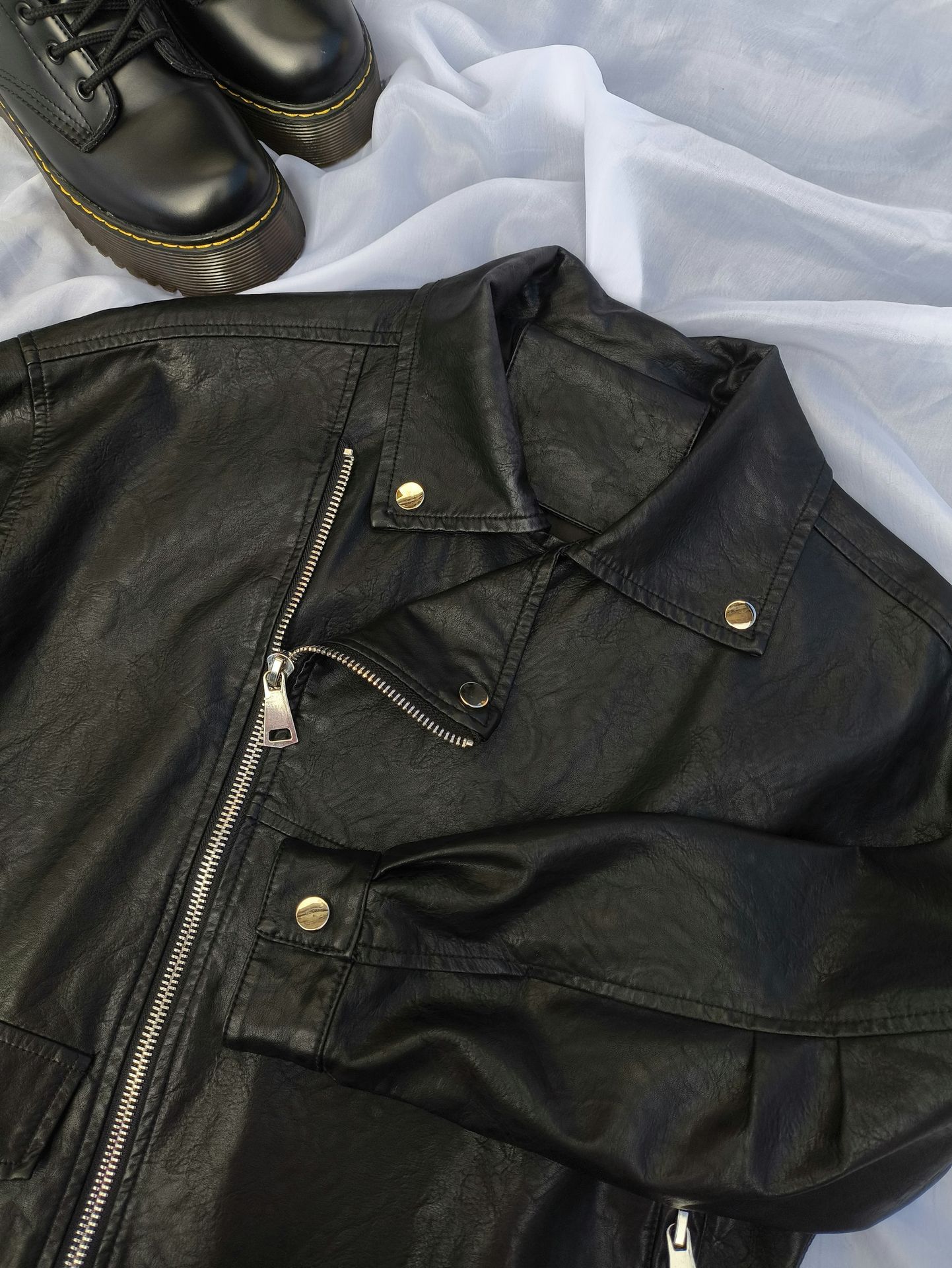 A pair of black shoes and a black leather jacket